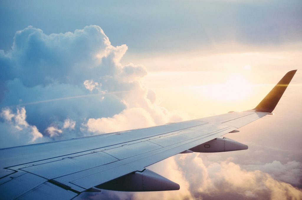 View of an aeroplane wing above the clouds at sunset