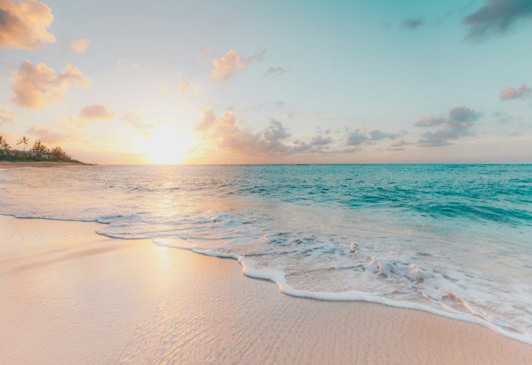 Turquoise sea meeting a white sand beach under a clear sky