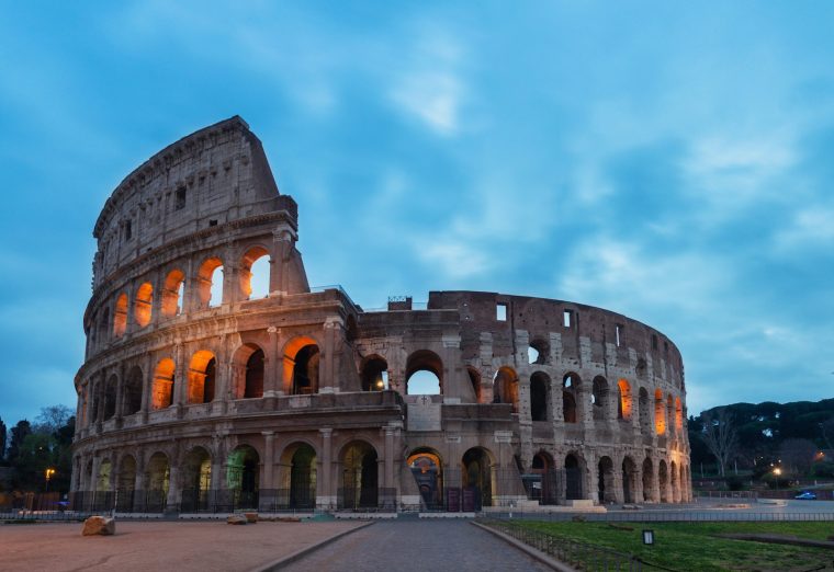 The Colosseum in Rome under a clear blue sky